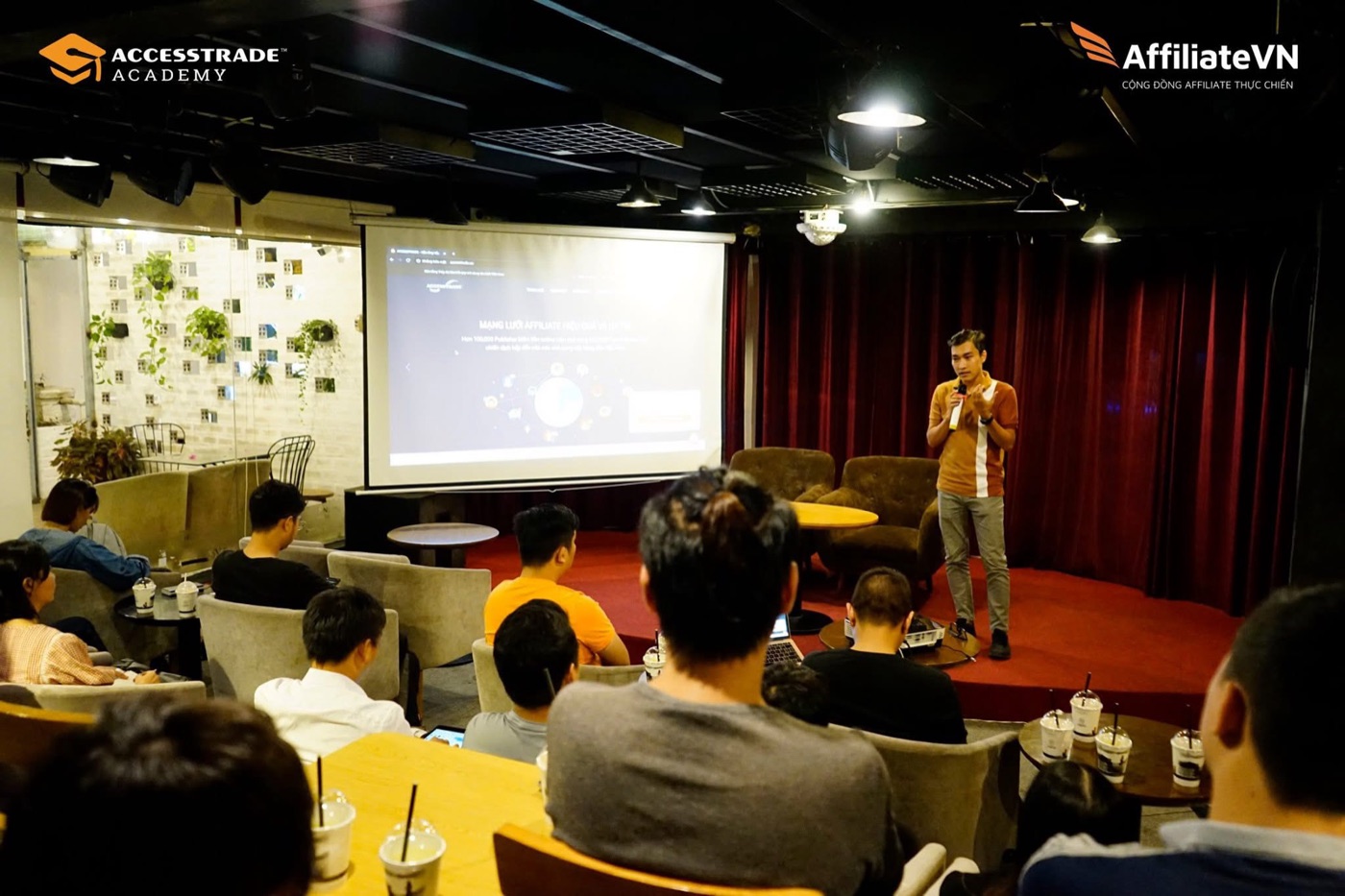 Hoàng Thanh Long cầm micro nói trước khán phòng tại một buổi offline về tiếp thị liên kết